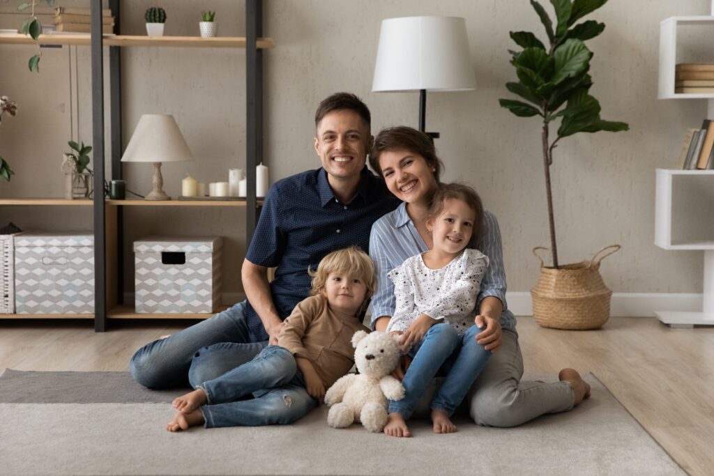 PortraitOfSmilingAffectionateYoungCoupleParentsAndAdorableLittle - Red Penny Realty